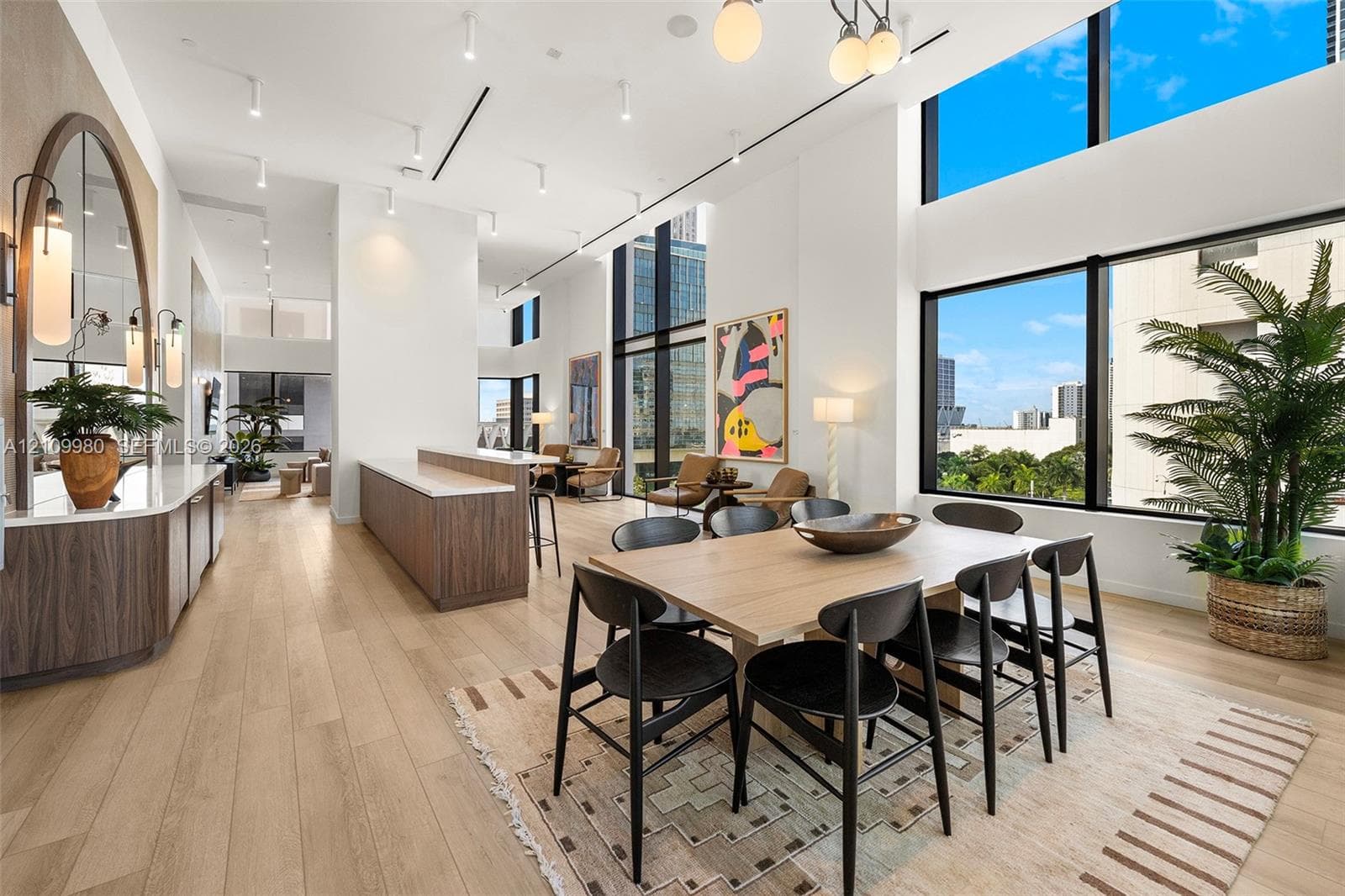 Double-height ceilings, floor-to-ceiling windows, wood-finish flooring, recessed lighting, and built-in cabinetry with stone-finish countertops