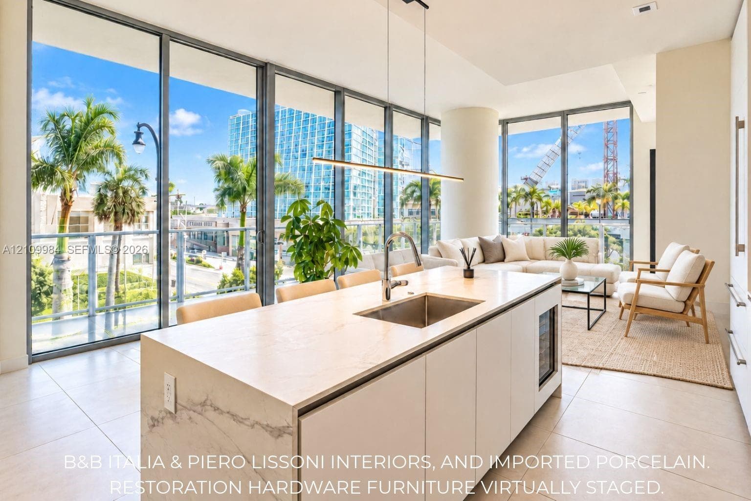Kitchen island with stone-surface countertop, under-mount stainless steel sink, built-in beverage refrigerator, floor-to-ceiling glass panel walls, and linear pendant lighting