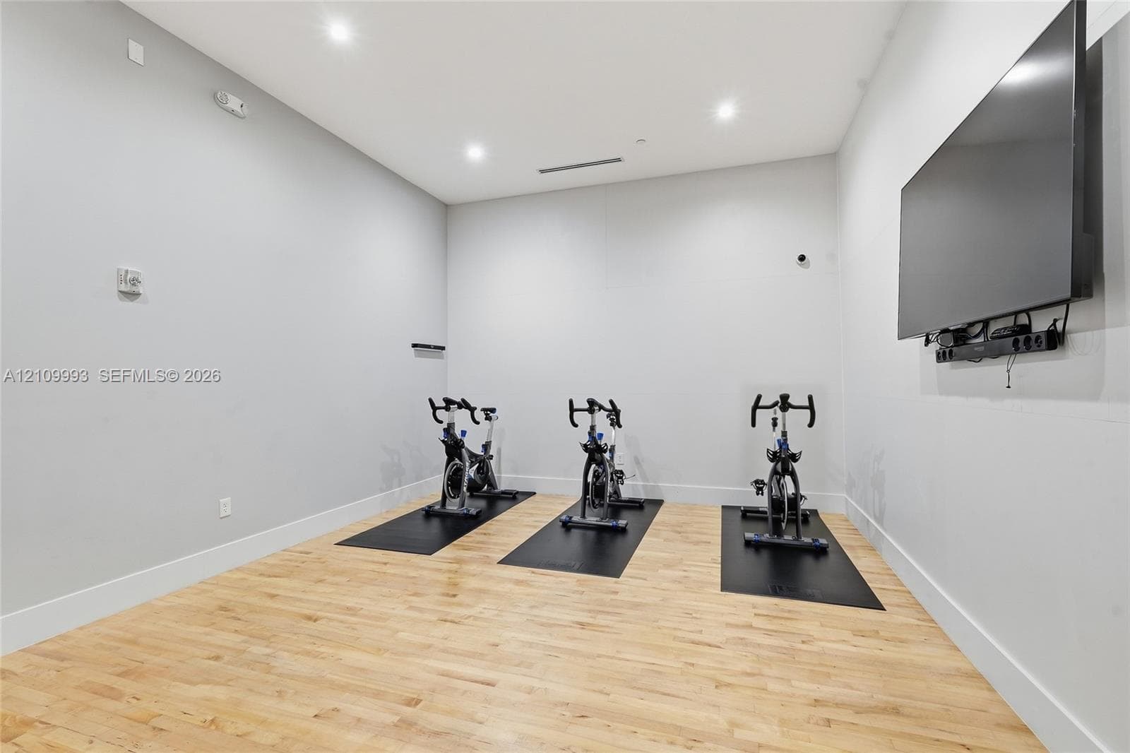 Room featuring wood-finish flooring, recessed lighting, and wall-mounted television
