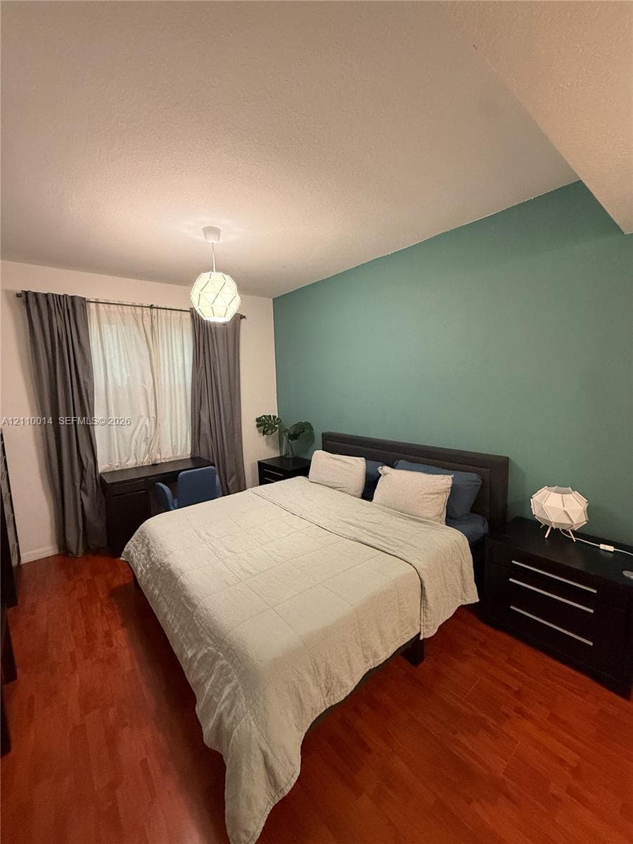 Wood-finish flooring, accent wall, and pendant light fixture