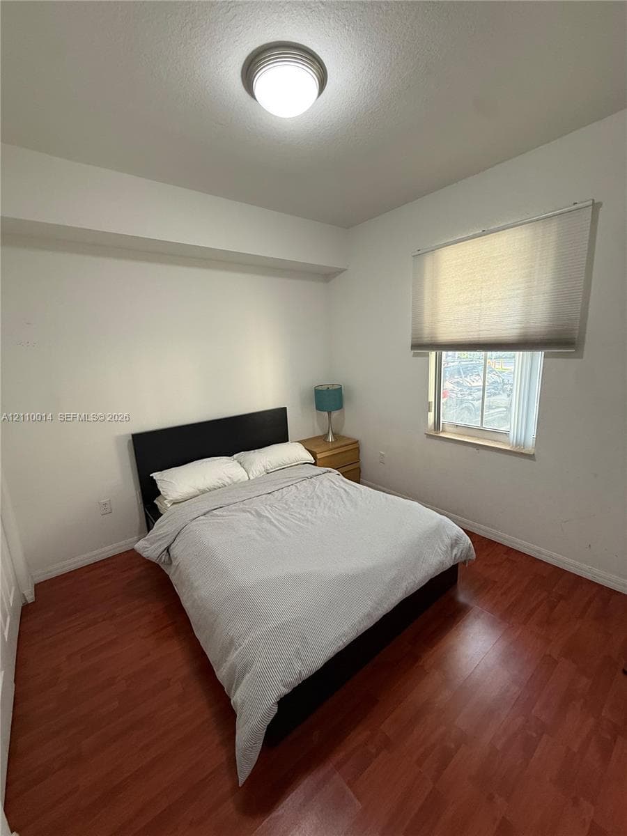 Wood-finish flooring, recessed ceiling light fixture, and window with an integrated pleated shade