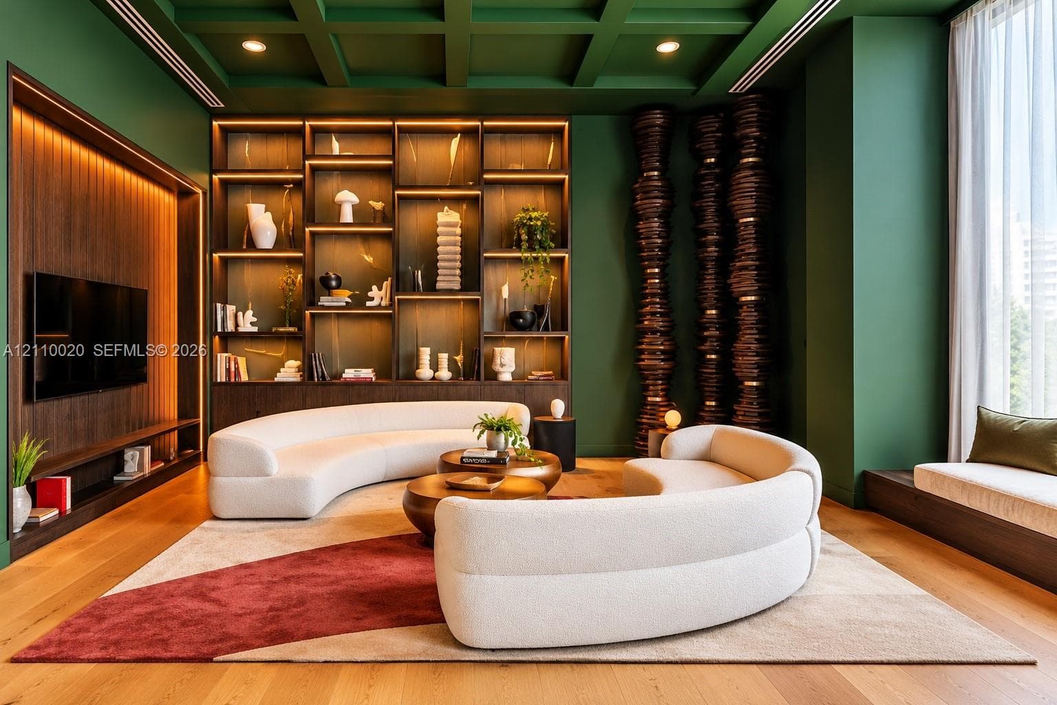 Coffered ceiling with integrated recessed lighting, expansive built-in floor-to-ceiling shelving with accent illumination, wood-finish flooring, and recessed display niche with integrated vertical lighting