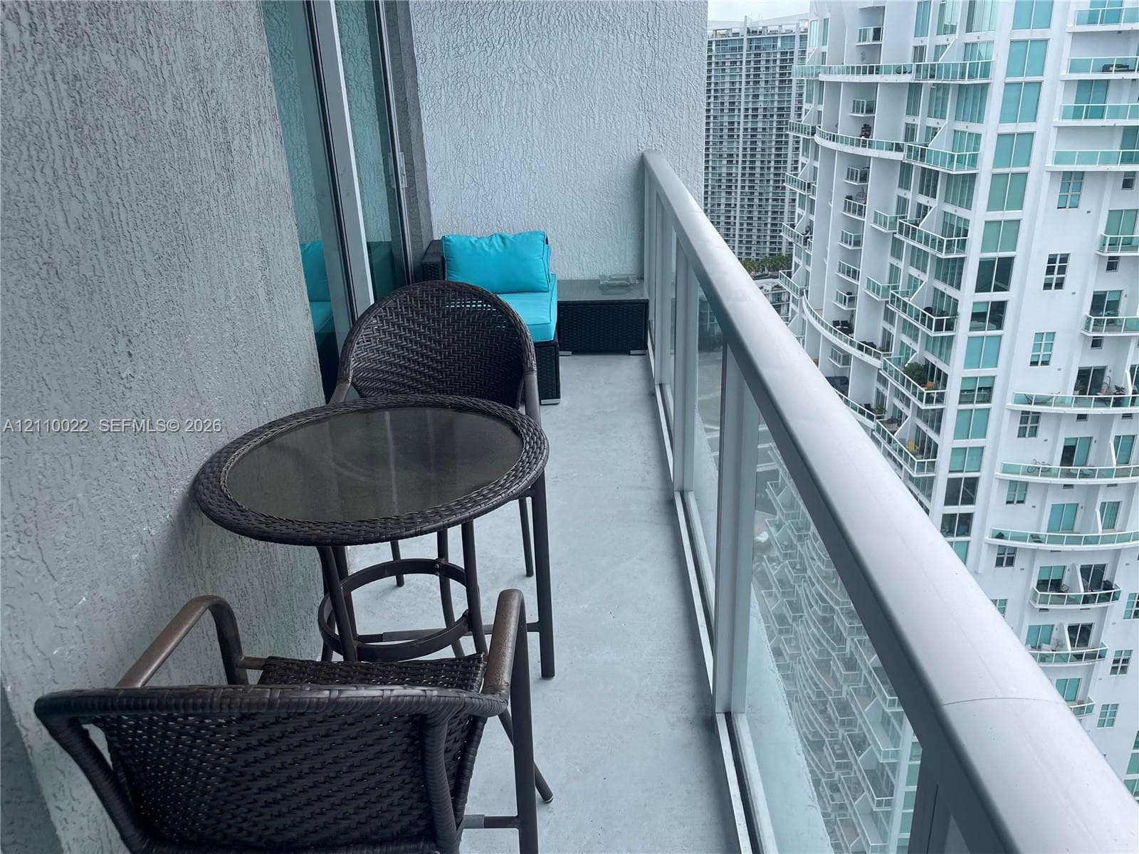 Private balcony featuring a glass panel railing and concrete flooring
