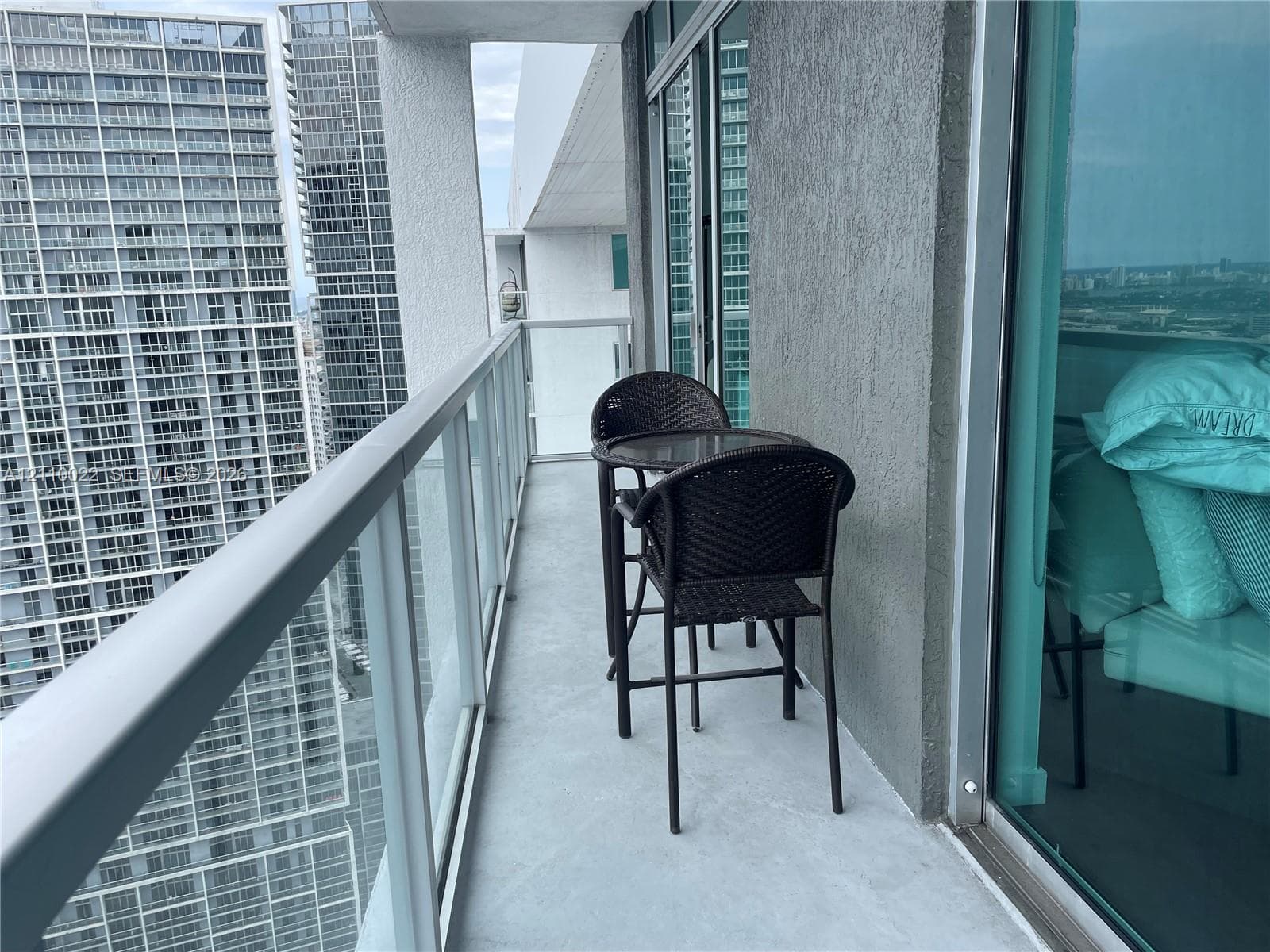 Private balcony featuring glass panel railing and concrete flooring