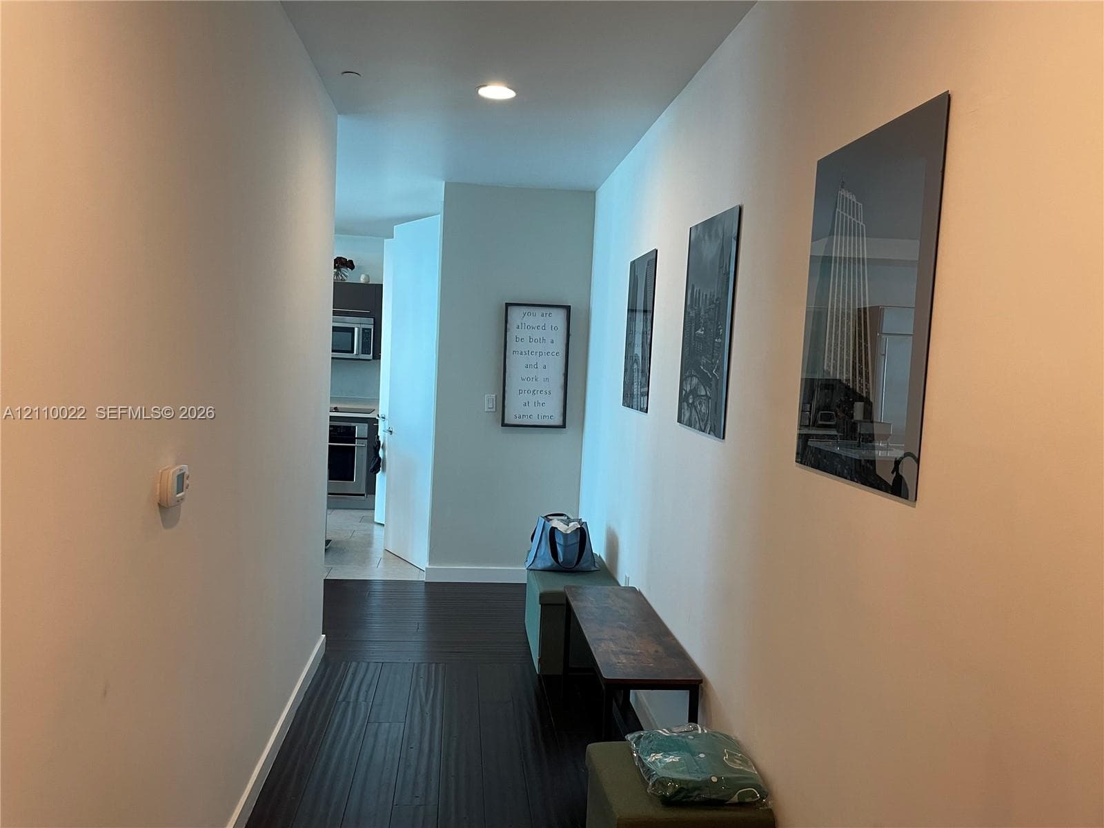 Hallway featuring wood-finish flooring, neutral wall tones, and recessed lighting