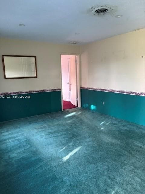 Room featuring full-height walls with decorative wainscoting and inset wall-mounted mirror