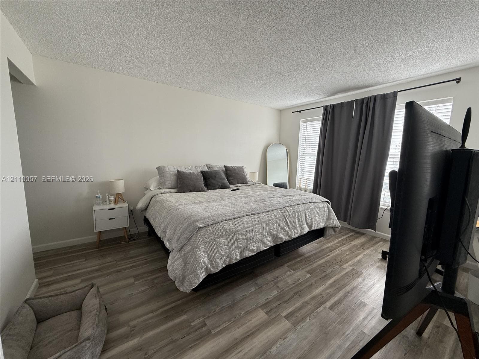 Wood-finish flooring and dual windows with curtain rod hardware