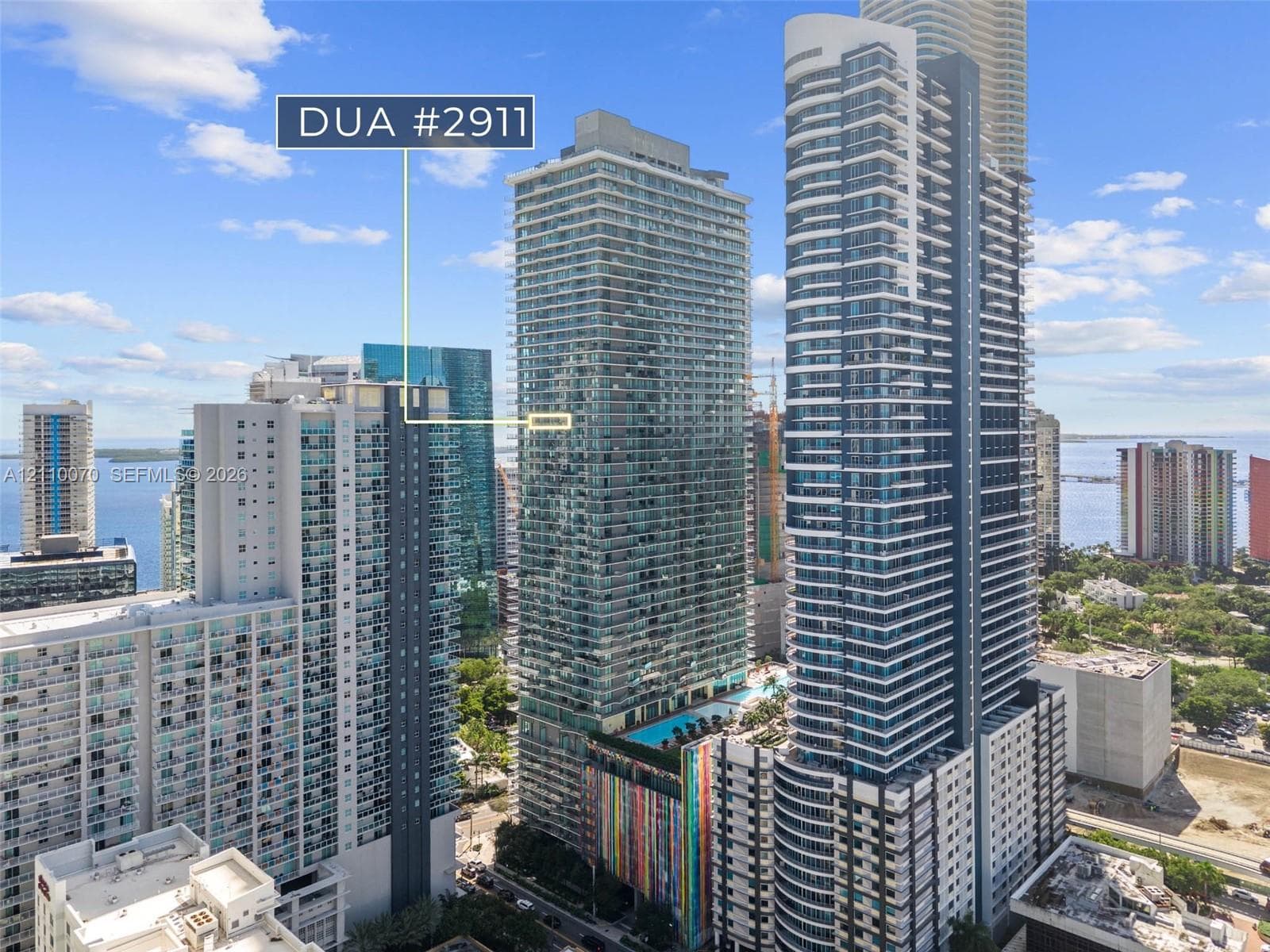 High-rise exterior featuring stepped balconies with glass railings and floor-to-ceiling sliding glass doors