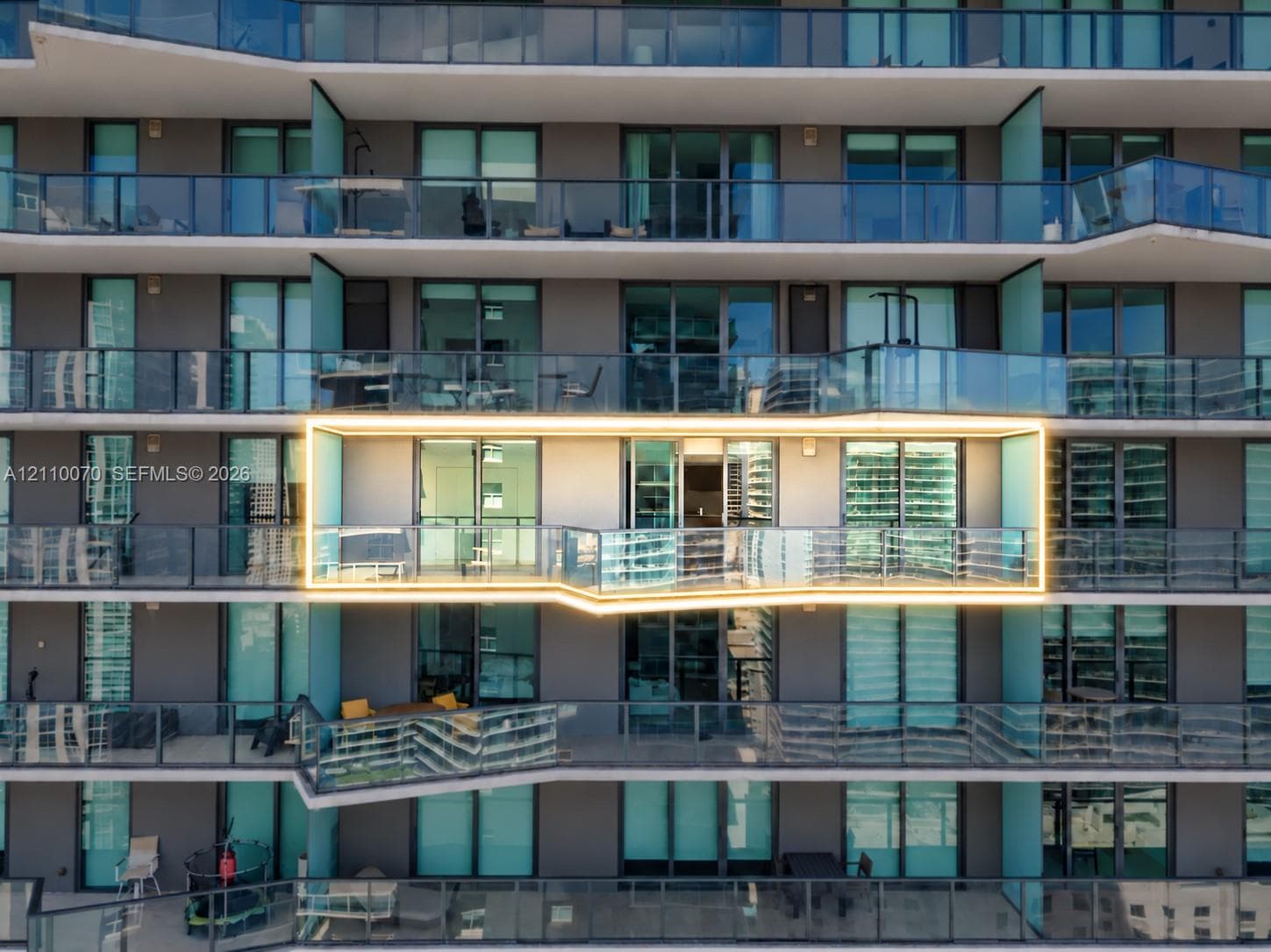 High-rise glass facade residential tower featuring floor-to-ceiling windows and private recessed balconies