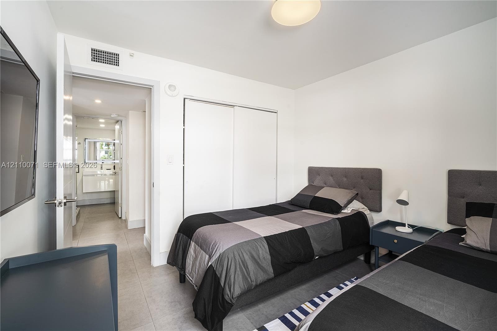 Neutral-toned room featuring hard-surface flooring, a dual-door closet, and flush-mount ceiling lighting