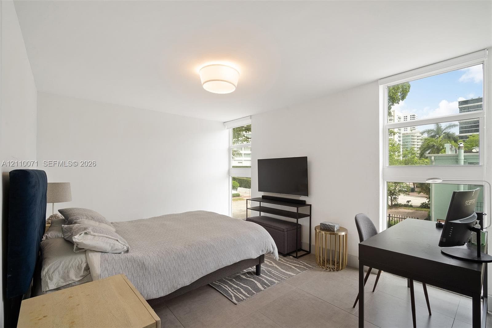 Neutral wall finishes, large-format tile flooring, oversized windows, and a flush-mount dome light fixture