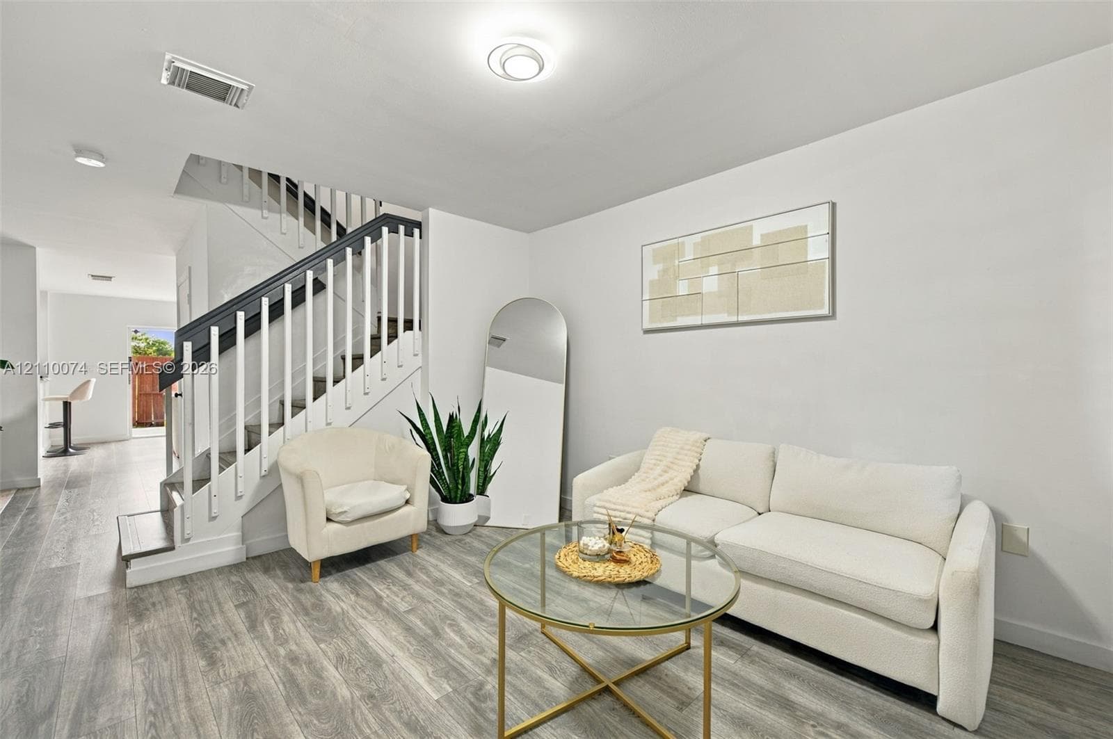 Staircase featuring white balusters with dark-toned handrails, wood-finish flooring, and recessed ceiling lighting