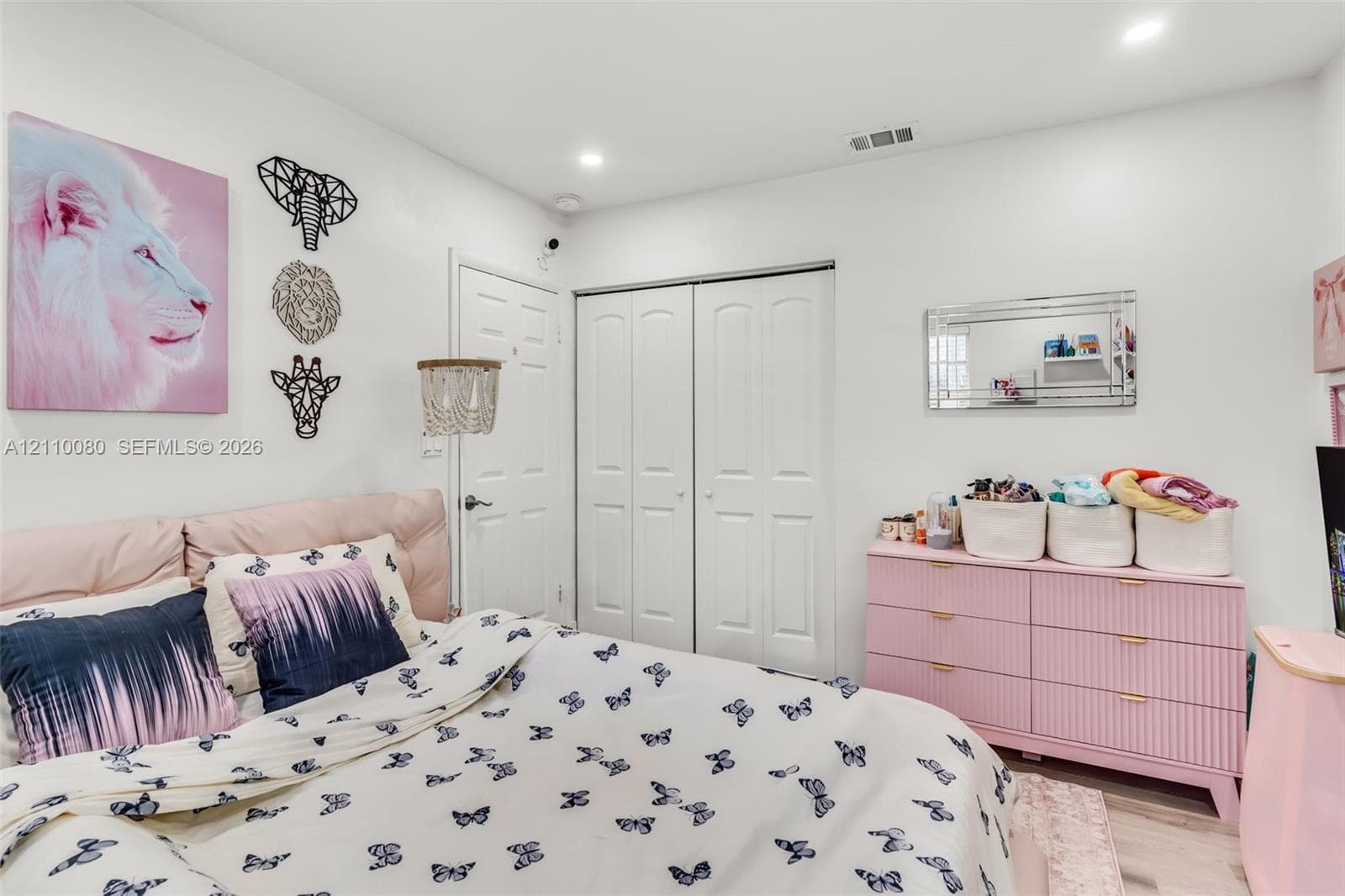 Bedroom featuring recessed lighting, a double-door closet with paneled detailing, and wood-finish flooring