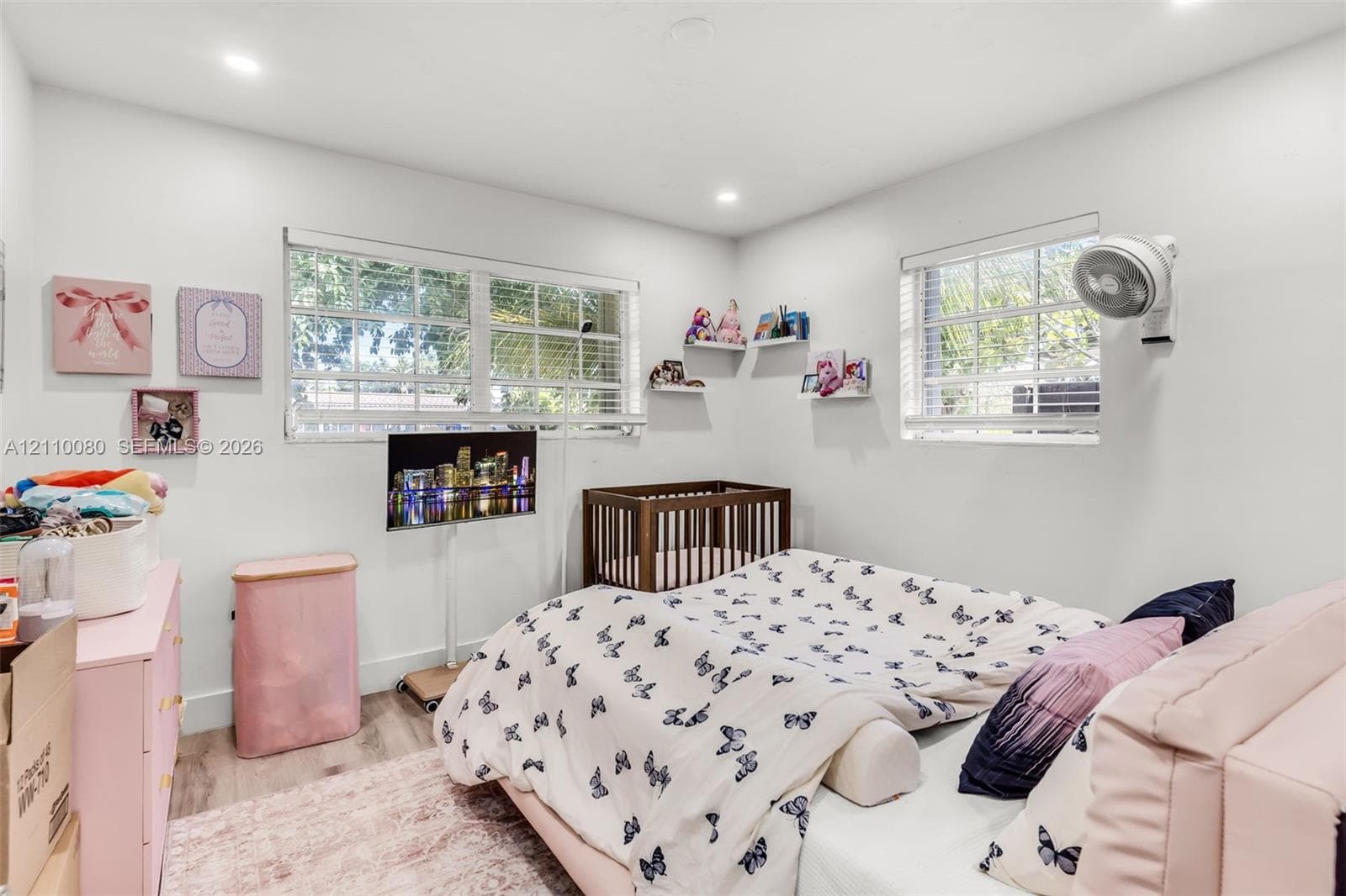 Room featuring wood-finish flooring, dual windows with blinds, recessed lighting, and built-in floating wall shelves