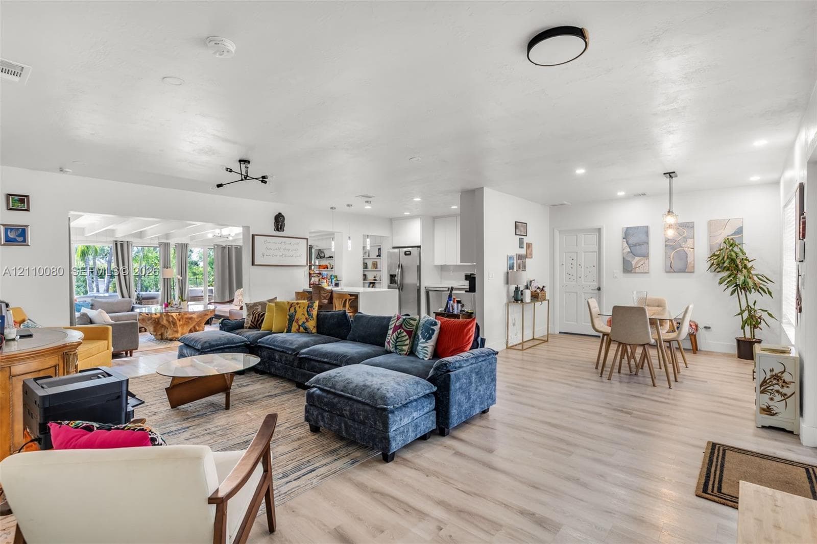 Open-concept living space featuring wood-finish flooring, recessed lighting, and a kitchen equipped with stainless steel appliances