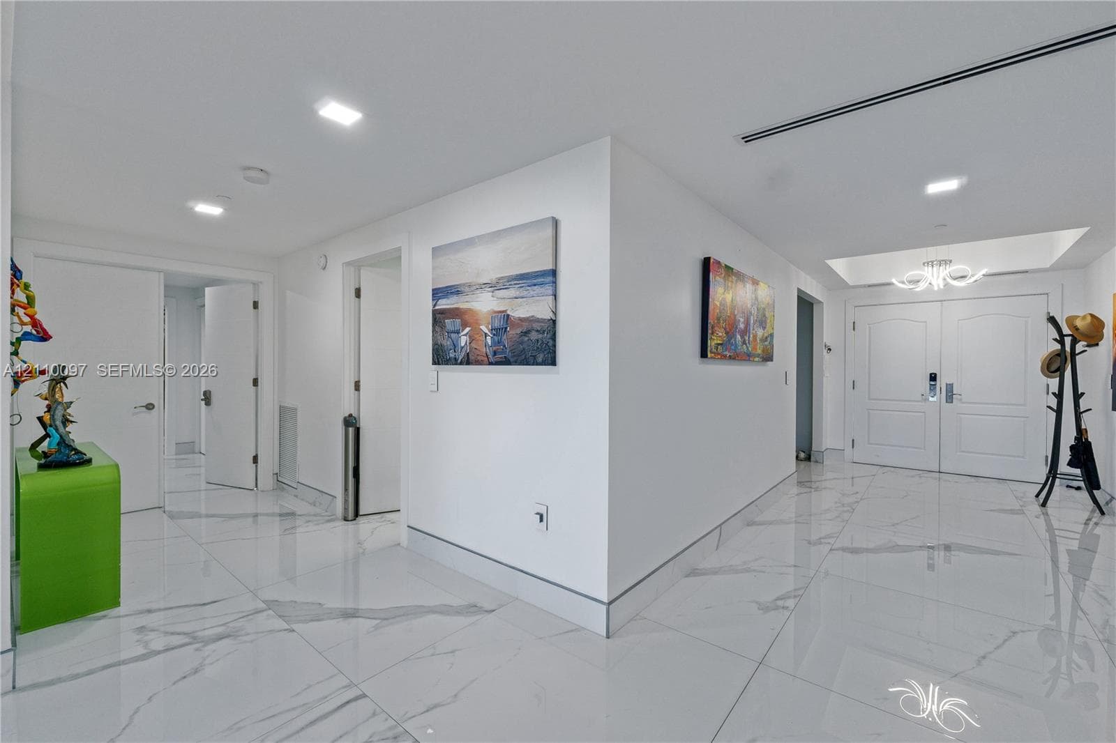Foyer featuring large-format veined tile flooring, recessed ceiling lighting, a tray ceiling detail, and double-entry doors