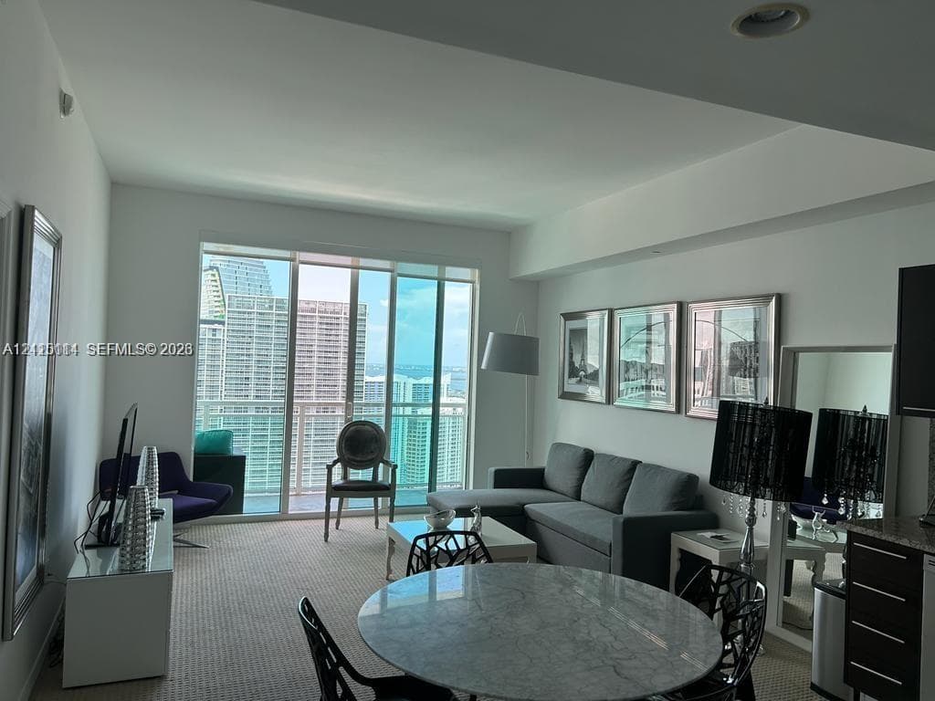 Floor-to-ceiling sliding glass doors, recessed lighting, and wall-to-wall carpeting