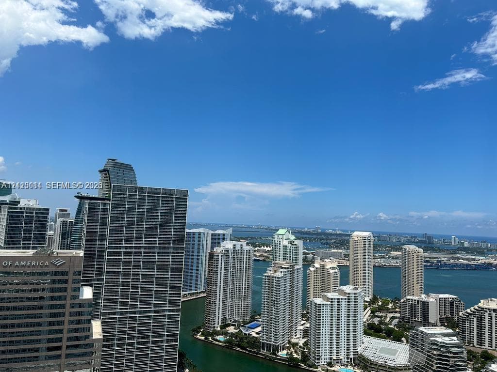 High-rise perspective featuring expansive urban skyline, coastal waterway, and horizon