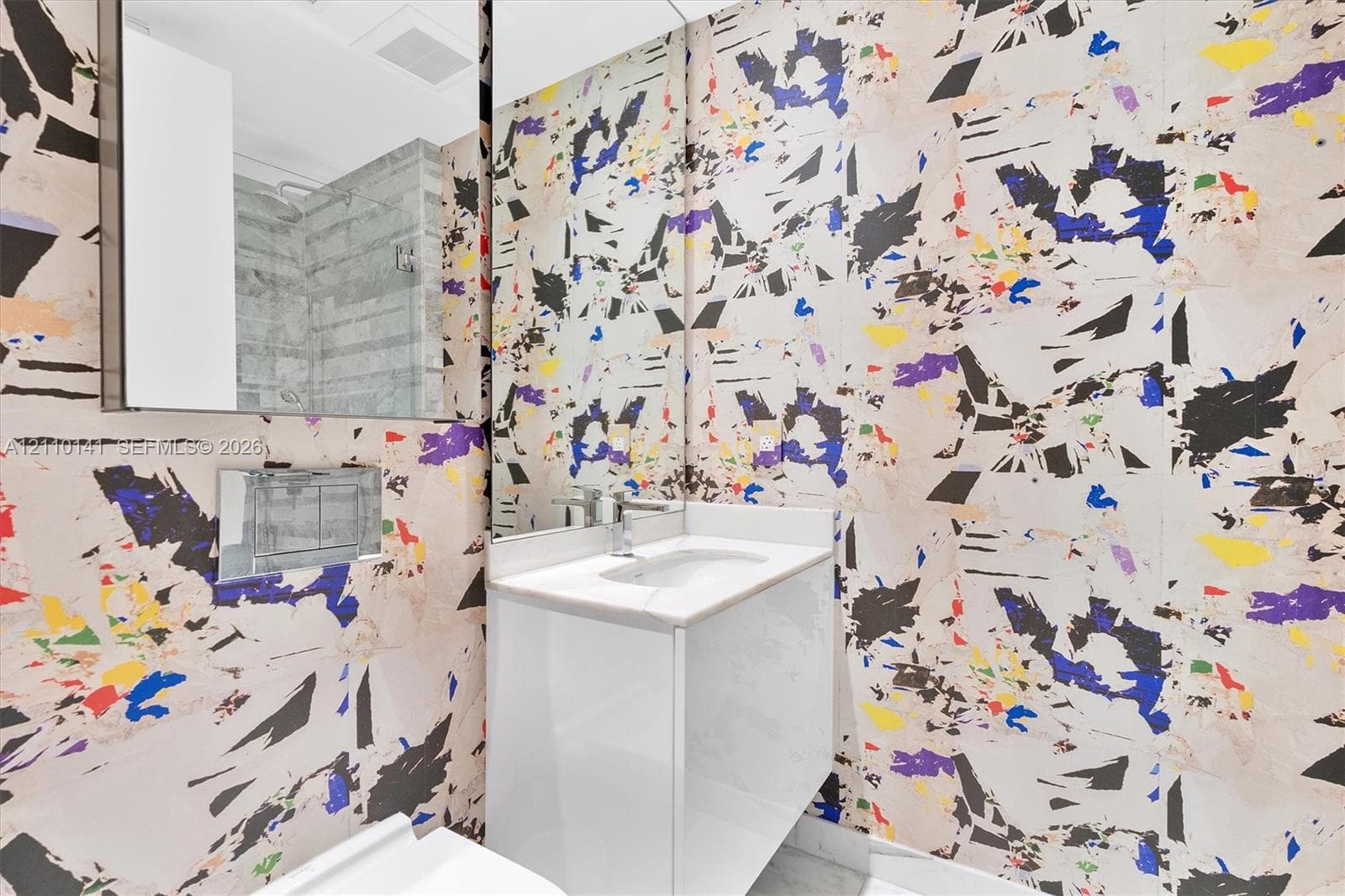 Designer Wall Covering ,Modern floating vanity with a white countertop and basin, wall-mounted chrome faucet, and expansive wall-to-wall mirror /guest bathrroom