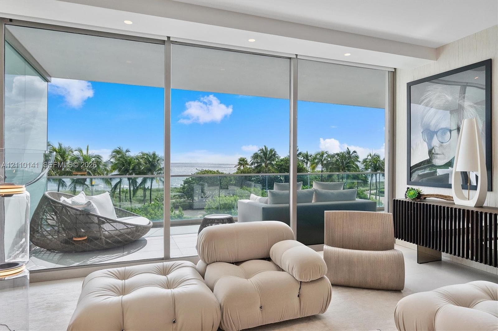 Floor-to-ceiling sliding glass walls, recessed ceiling lighting, and a private balcony with glass railingcorner unit overlooking direct ocean views