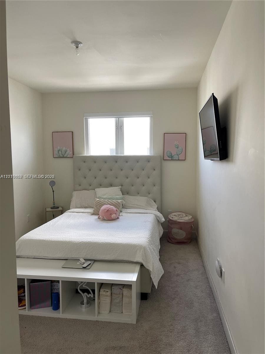 Room featuring wall-to-wall carpeting, neutral-toned walls, and a window with a white frame