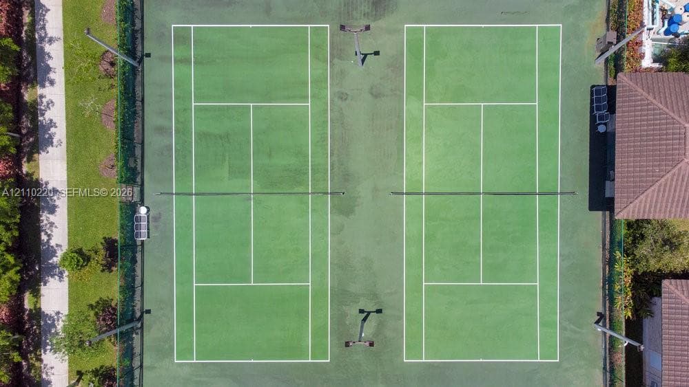 Dual tennis courts featuring professional-grade perimeter fencing, integrated lighting systems, and marked hard-surface play areas