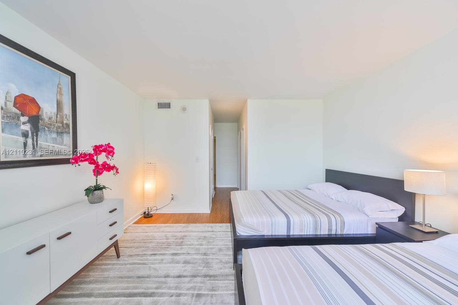 Spacious room featuring neutral paint, wood-finish flooring, and crisp architectural lines