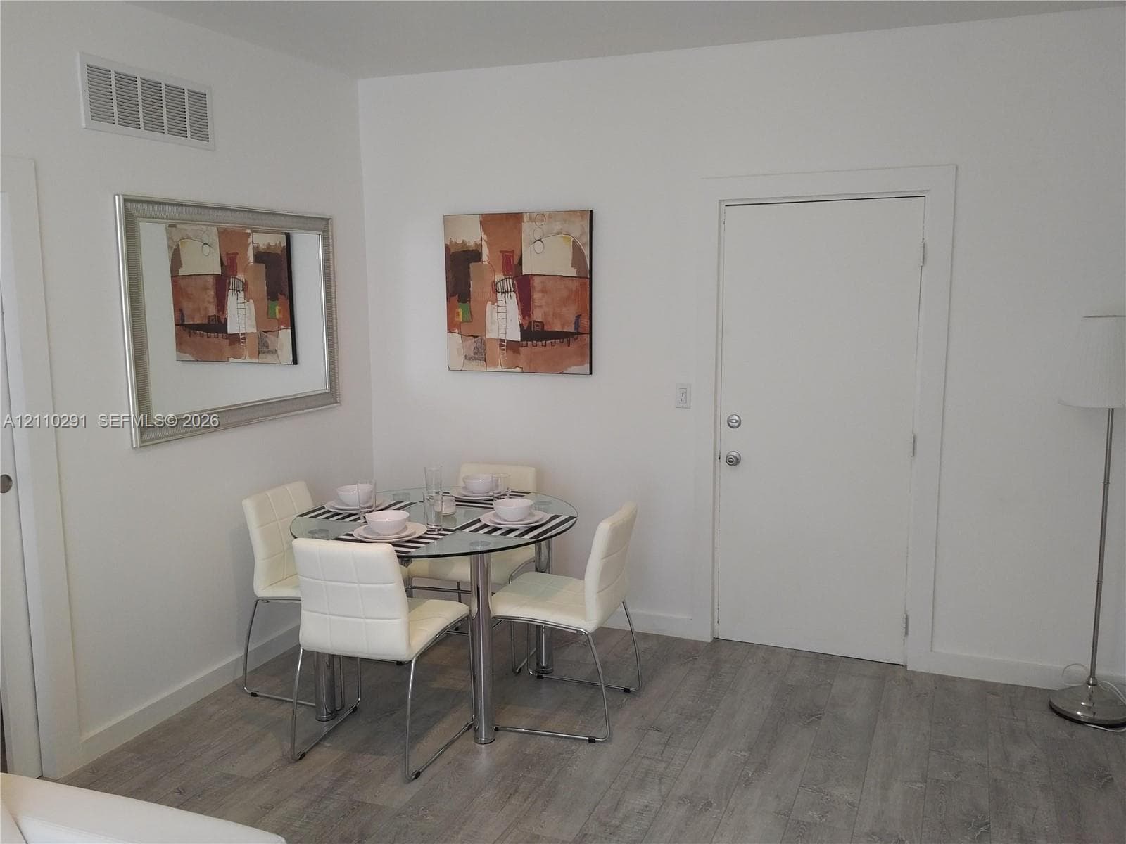Wood-finish flooring paired with neutral wall tones and interior door with brushed nickel hardware