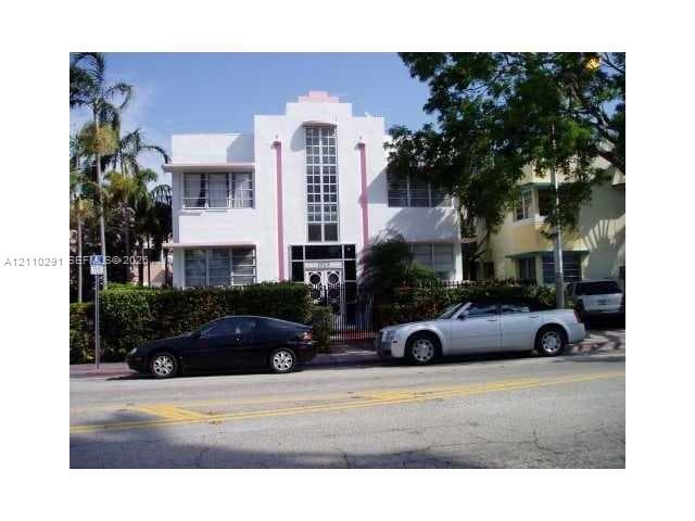 Art Deco architectural facade featuring smooth stucco siding, tiered roofline, vertical glass block elements, and iron-grille entry door