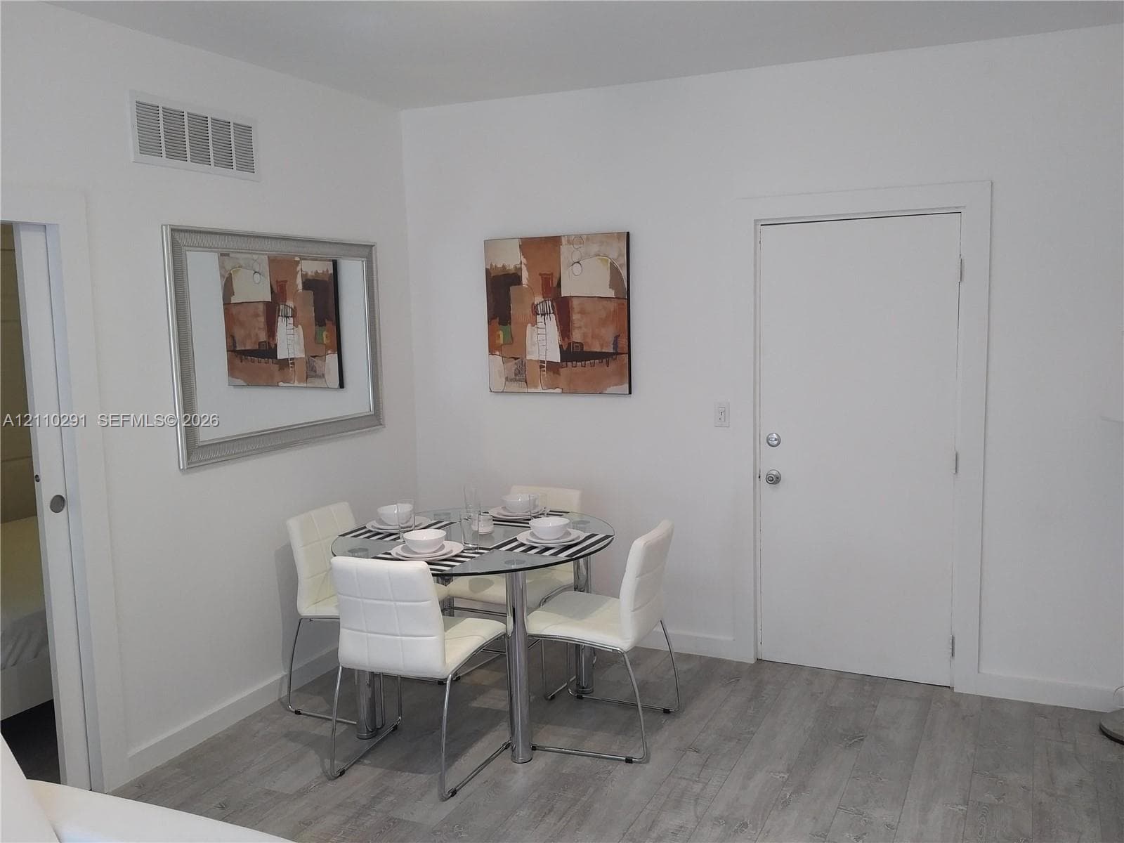 Neutral-toned wood-finish flooring and solid core white interior doors
