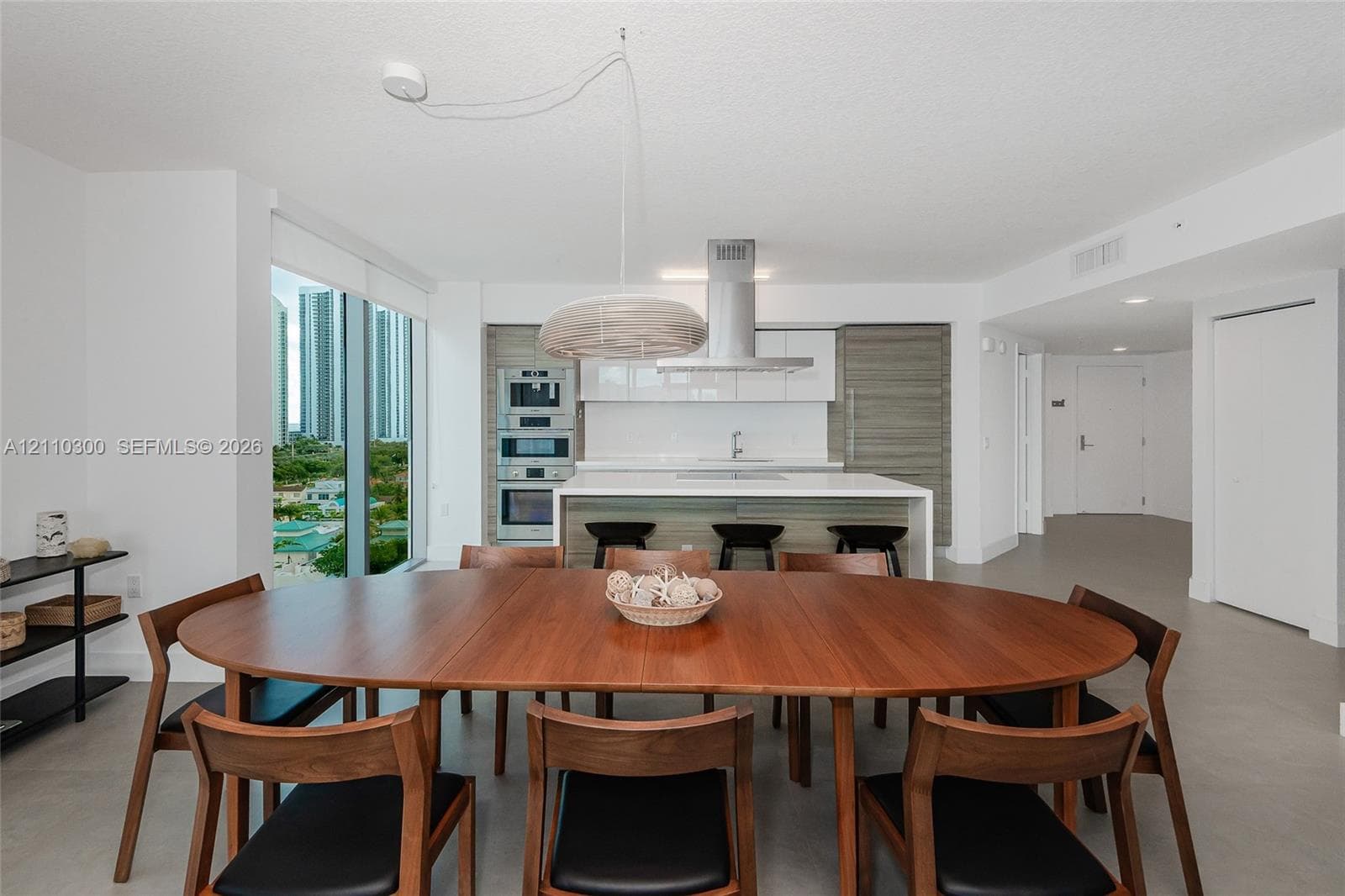 Floor-to-ceiling glass windows, wraparound balcony, neutral tile flooring, and recessed ceiling lighting