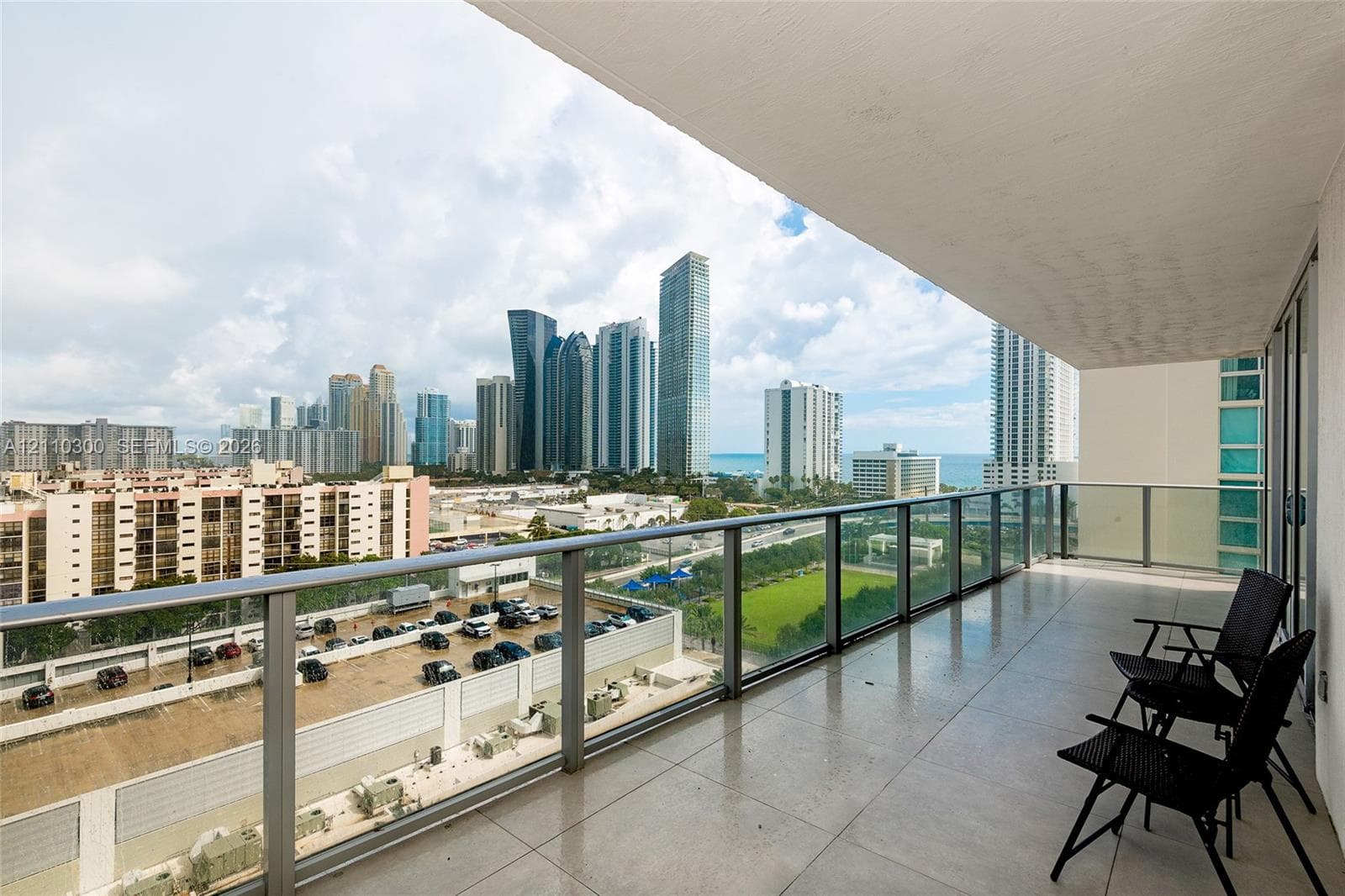 Private balcony featuring a glass panel railing and tile flooring. Ocean View