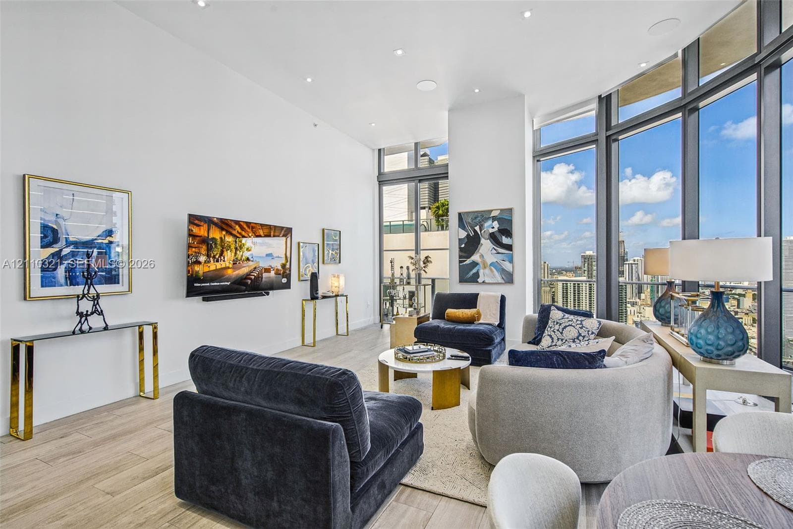 Open-concept interior featuring floor-to-ceiling windows, wood-finish flooring, recessed lighting, and built-in ceiling speakers