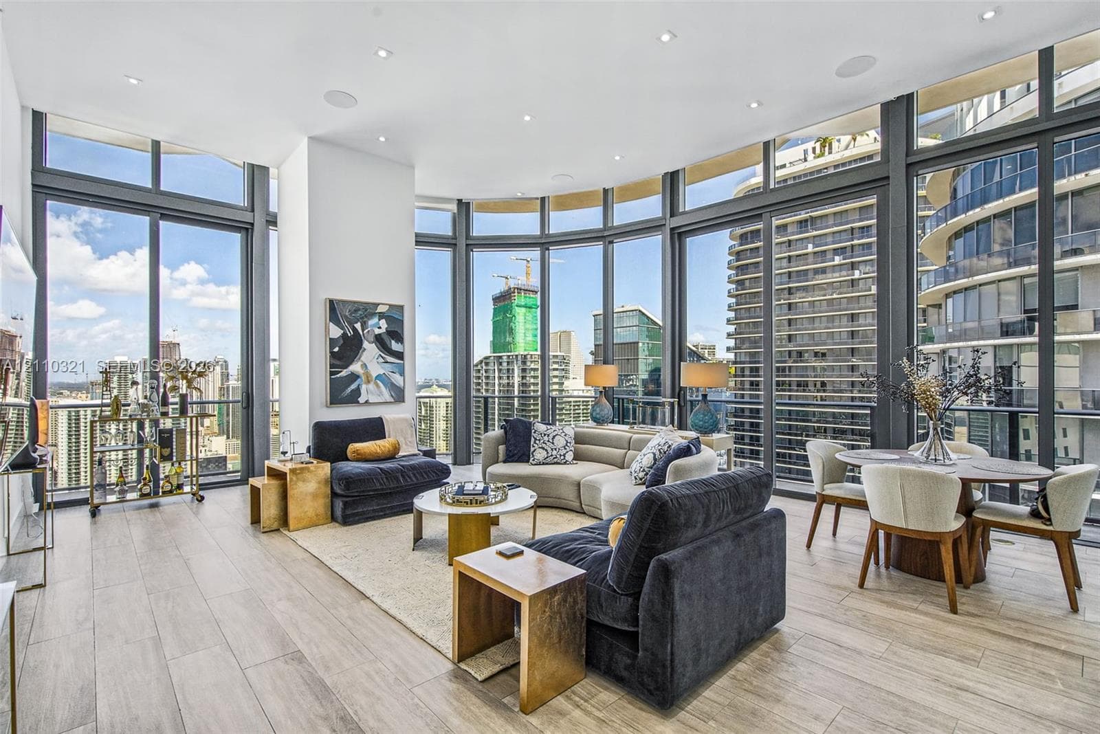 Floor-to-ceiling windows with expansive urban outlooks, wood-finish flooring, and recessed ceiling lighting