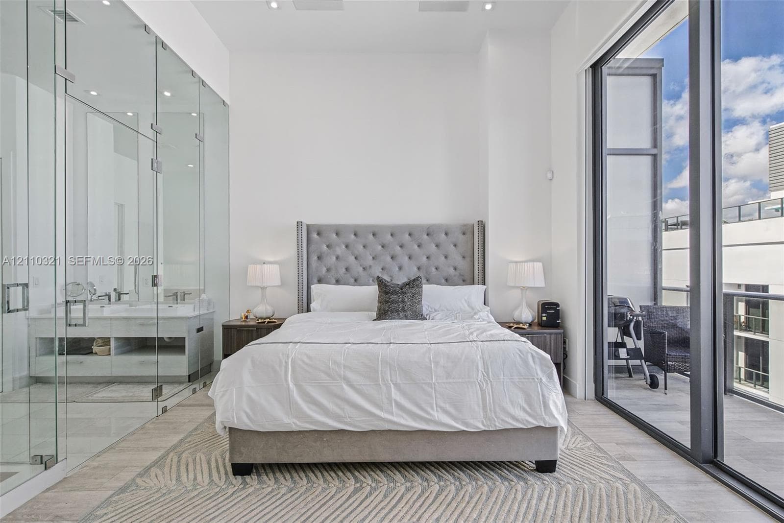 Floor-to-ceiling glass wall enclosure, full-height windows, neutral-toned flooring, and recessed ceiling lighting