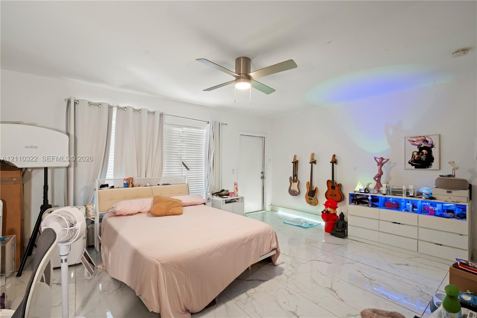 Large-format tile flooring, multi-blade ceiling fan with integrated lighting, and horizontal window blinds