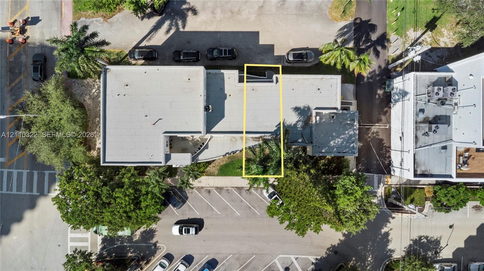 Aerial perspective featuring a flat-roof structure with designated surface parking