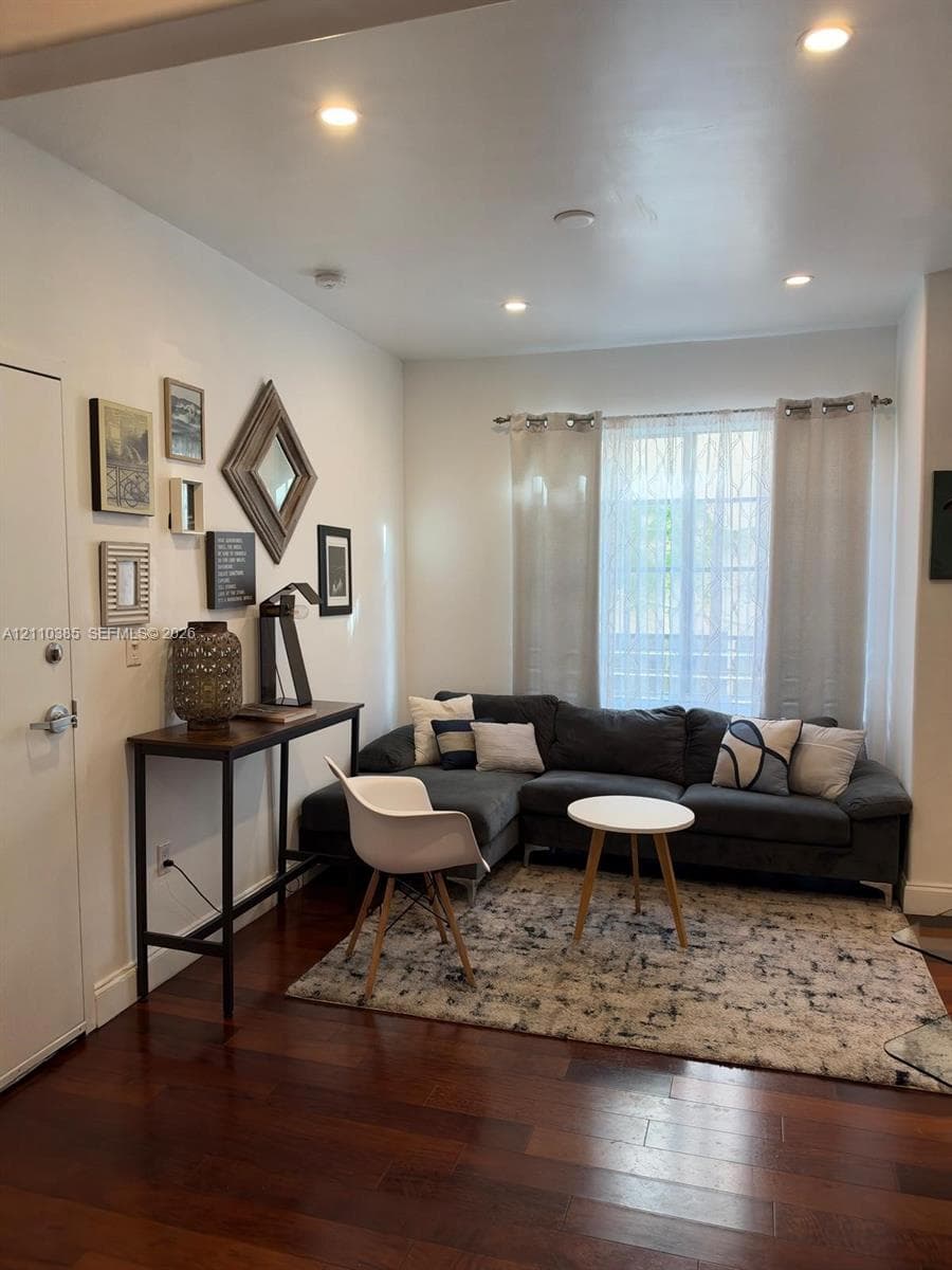 Wood-finish flooring, recessed lighting, and a large window with horizontal blinds