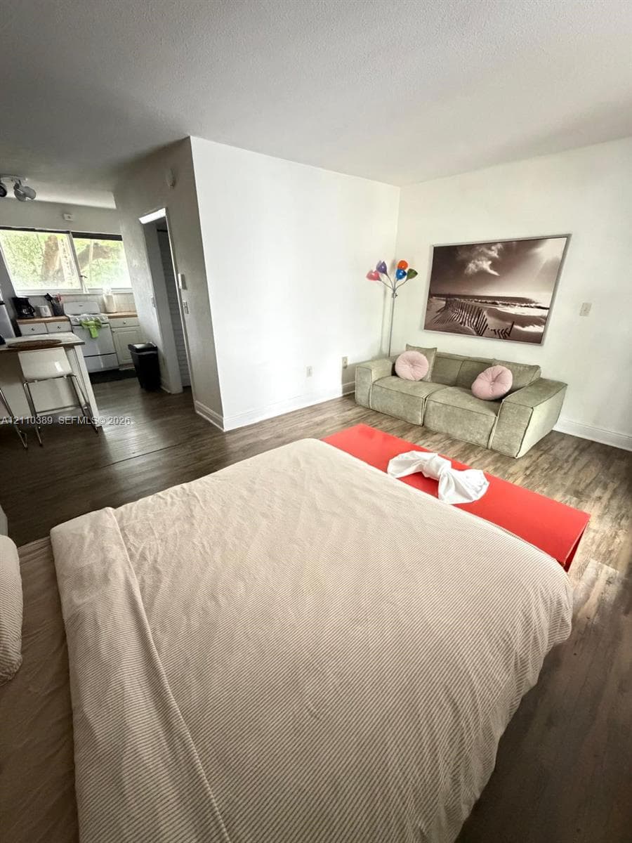 Wood-finish flooring, kitchen island, and white wall finishes
