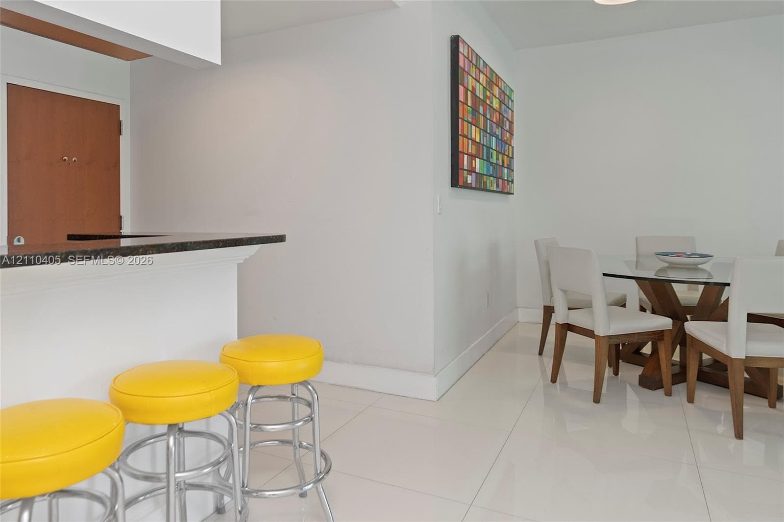 Dining area featuring polished tile flooring and a breakfast bar with stone-surfaced countertop