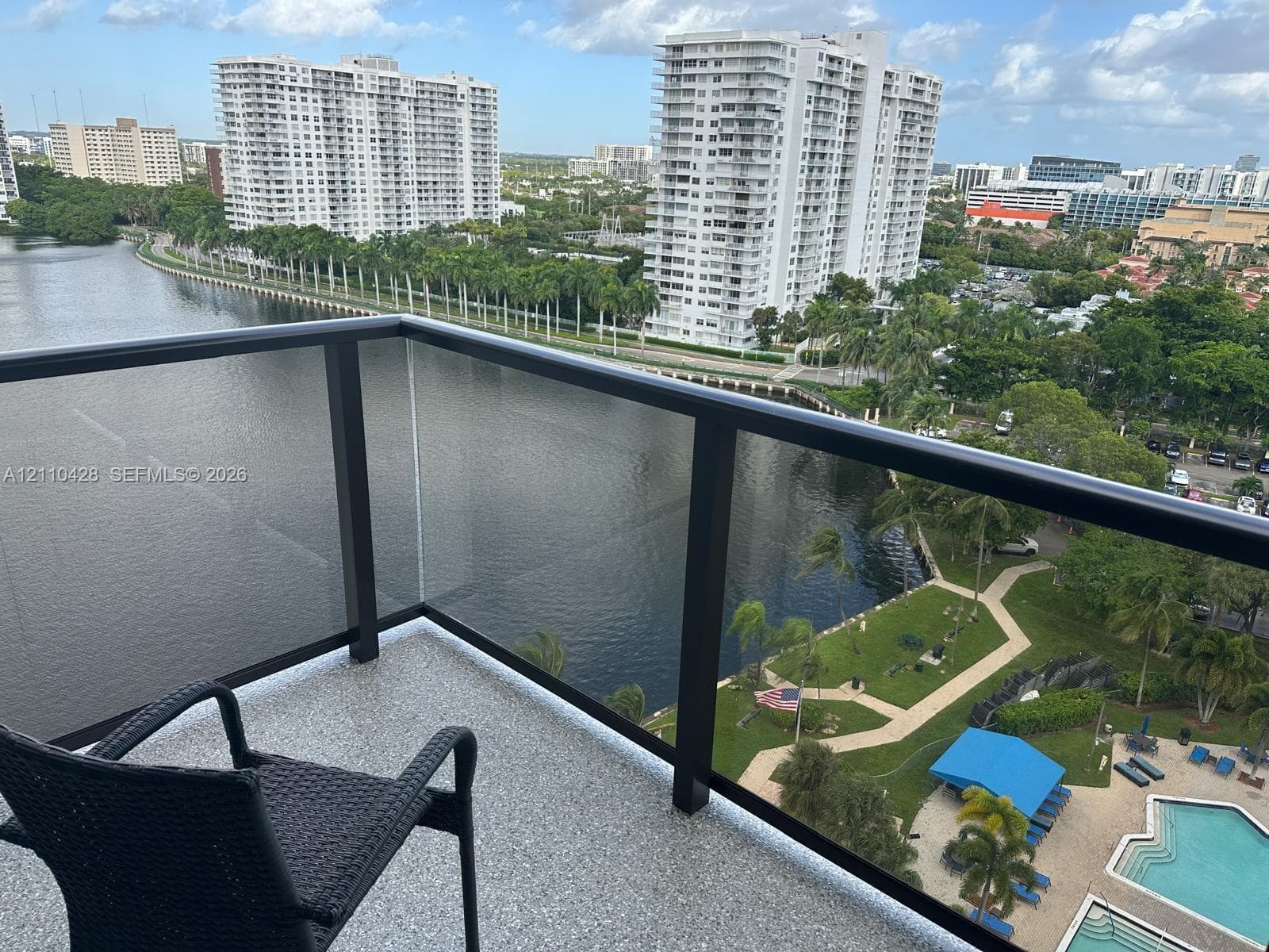 Private balcony featuring a black-framed glass railing and textured flooring