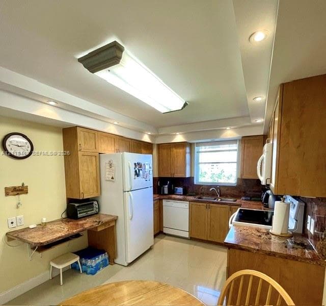 Kitchen featuring wood cabinetry, stone-finish countertops, recessed ceiling lighting, a double-basin sink, and tile flooring