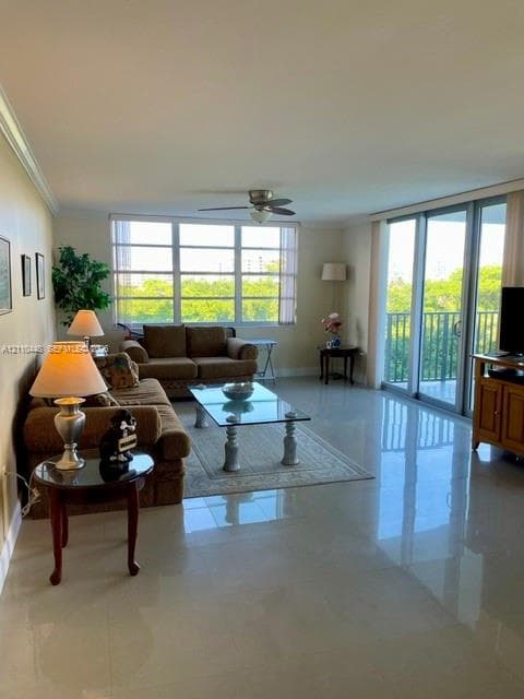 Large-format tile flooring, oversized picture windows, sliding glass balcony doors, and a ceiling-mounted fan