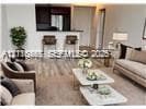 Open-concept interior featuring wood-finish flooring, a kitchen breakfast bar, and recessed lighting