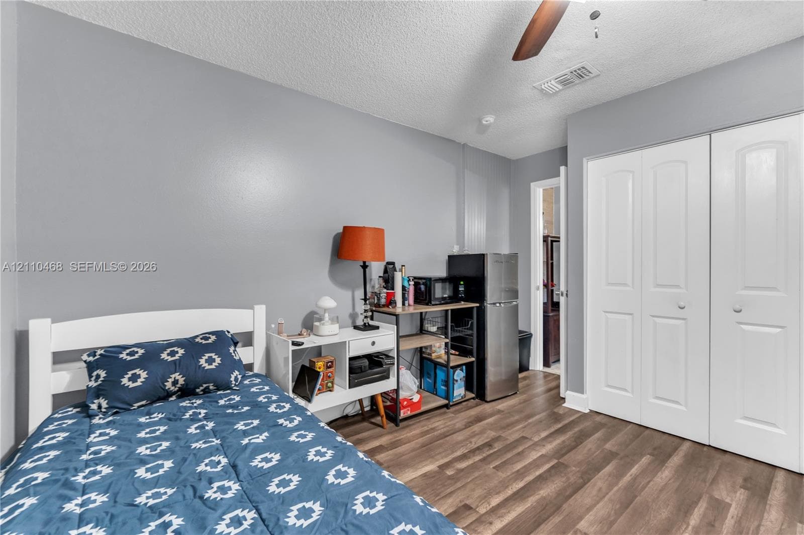 Wood-finish flooring, double-panel closet doors, and ceiling fan fixture