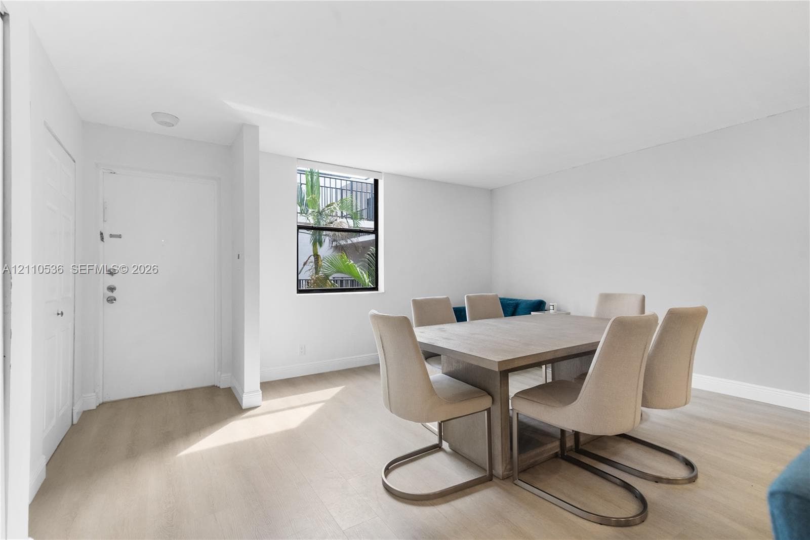 Light-filled interior featuring wood-finish flooring, white walls, and a single-pane window