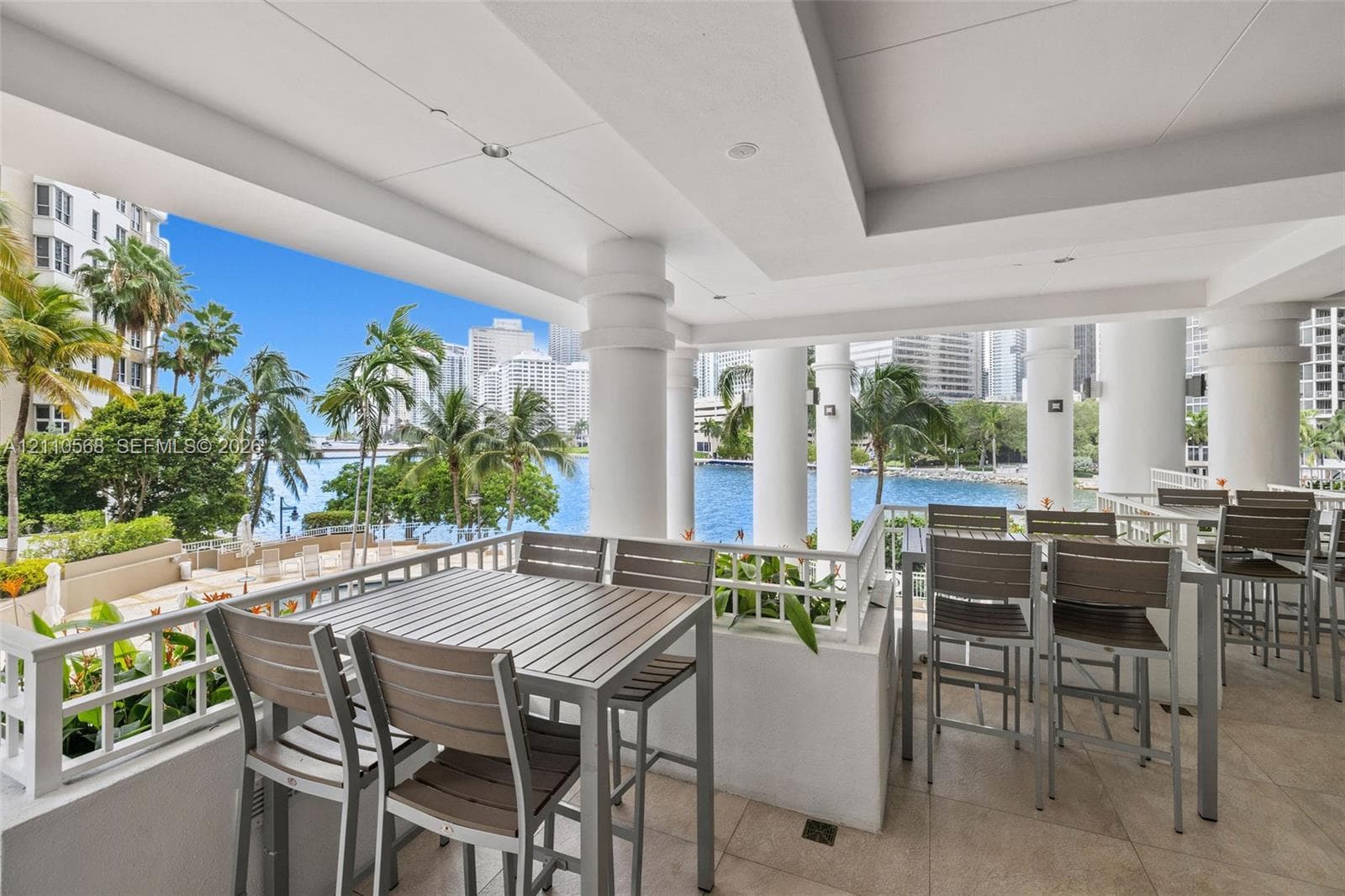 Covered terrace featuring stone tile flooring, structural columns, and integrated recessed lighting