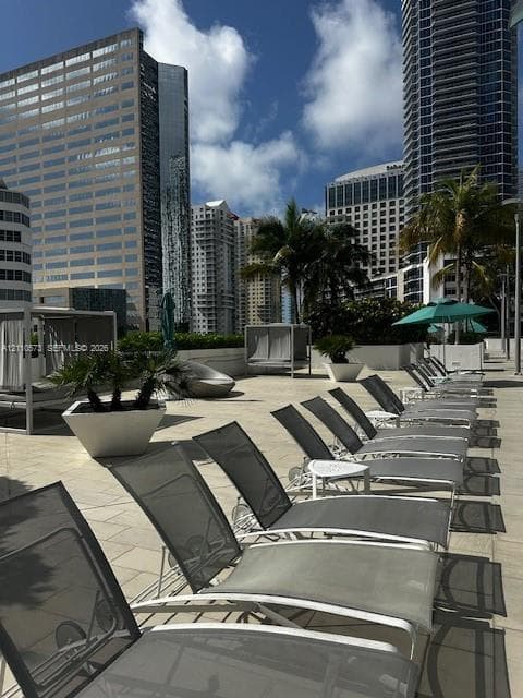 Outdoor terrace featuring stone-tile flooring, perimeter planters, and metal-frame structures