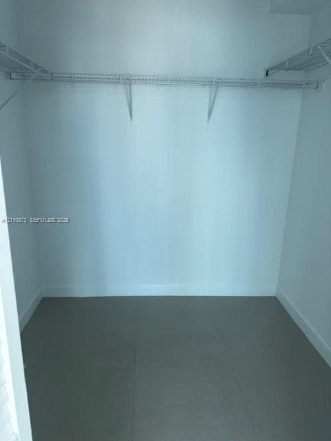 Storage space featuring wall-to-wall wire shelving and neutral tile flooring