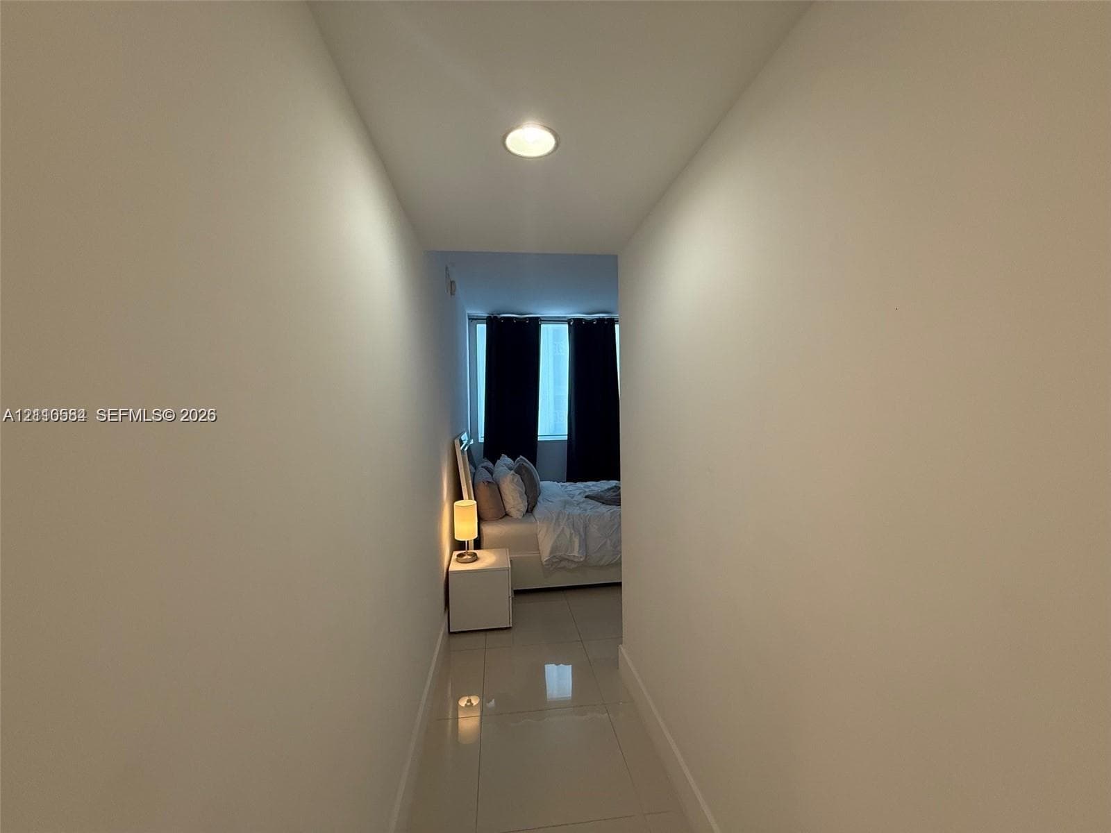 Hallway featuring high-gloss tile flooring and recessed ceiling lighting